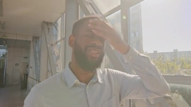 Afrikalı Amerikalı iş adamı portresi koridorda yürüyen gömlekli yönetici adam sıcağa yakalanmış gibi hissediyor. Kendi kendine yüksek hava sıcaklığı dalgaları yaz günü soğuyor. — Stok video