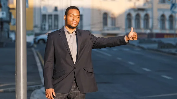 Çekici Afrikalı Amerikalı öğrenci, takım elbiseli genç adam dışarıda taksi bekliyor. Modern iş adamı ya da müdür büyük şehirde araba sürücüsüne işaret veriyor. Taksi servisi kavramı — Stok fotoğraf