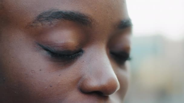 Gros plan visage noir féminin jeune afro-américaine jeune fille regardant la caméra avec de beaux yeux sombres, belle femme africaine dame avec une bonne vision vue avec de longs cils maquillage, ophtalmologie — Video