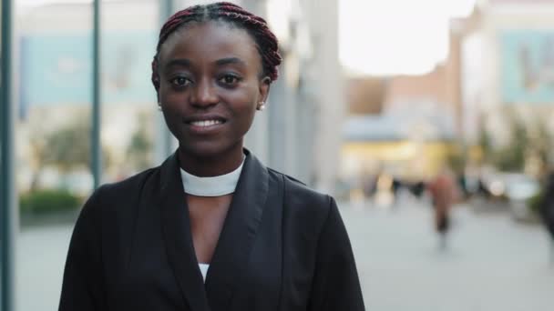 Portrait gros plan visage féminin belle femme d'affaires afro-américaine élégante souriante dent regardant la caméra confiante. Afro fille debout fond de ville urbaine regarder avec sourire concept de personnes réelles — Video