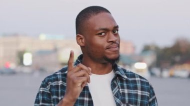 Afro-Amerikan genç iş adamı afro adam şehir sokaklarında dikiliyor. Parmak sallıyor. Anlaşmazlık jesti.