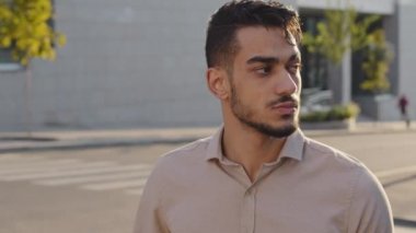Yakın plan portre ciddi erkek turist Arap işadamı yaya geçidinde arka planda duruyor ve sorun için sokakta kaybolmayı bekliyor.
