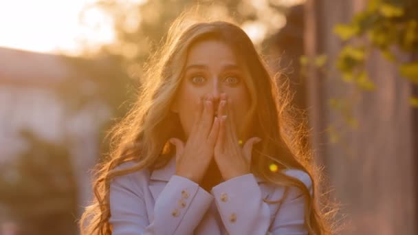 Portret in zonlicht zonsondergang zon blij verrast blij extatisch geschokt Kaukasisch meisje vrouw bedekt mond met handen van verrassing shock vreugde springen voor vreugde winnen viert overwinning zegt ja — Stockvideo