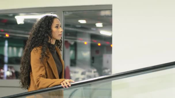 Compradora segura hermosa mujer de negocios caminando en el interior de pie en el centro comercial en escaleras mecánicas joven consumidor camina en el centro comercial. Mujer va moviendo escaleras se mueve en compañía de la oficina — Vídeos de Stock