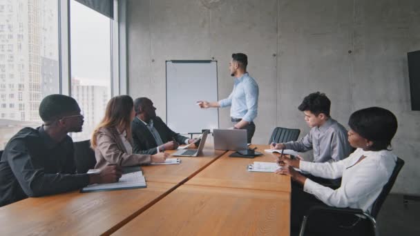 Framgångsrik manlig chef ledare man mentor skriver ombord i office presentation till multiracial affärspartners investerare grupp av chefer i moderna kreativa företag brainstorming företagsutbildning — Stockvideo