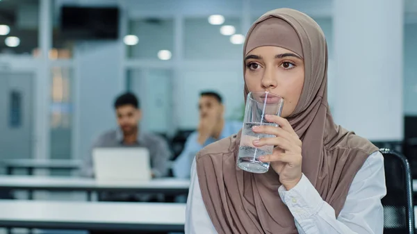 Törstig tusenårig indian arabiska kvinnliga arbetare i hijab innehav glas dricka rent mineralvatten på kontoret, omtänksam uttorkad kvinna anställd njuter av färsk aqua. Begreppet hälsosam livsstil — Stockfoto