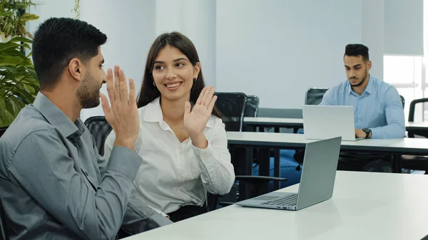 Los socios comerciales indios y caucásicos que discuten el nuevo proyecto en la reunión en el coworking usando el ordenador portátil, interactuando, comparten pensamientos desarrollan ideas dando los cinco altos. Tutoría, concepto de intercambio de habilidades —  Fotos de Stock