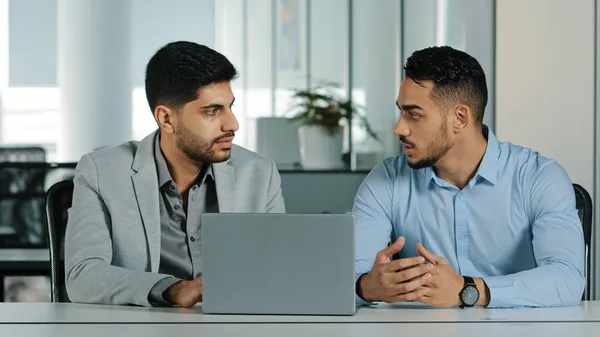 Confident arabic male financial consultant adviser expert talking to indian client customer explain commercial investment deal benefit show computer presentation at bank loan negotiation meeting