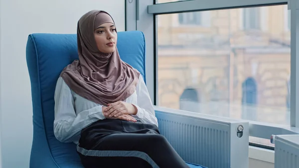 Studentessa araba stagista in hijab in attesa di esame o colloquio risultati in poltrona. Il candidato di lavoro si siede all'ufficio dell'agente di reclutamento che aspetta l'incontro con il datore di lavoro per l'assunzione. HR, concetto di carriera — Foto Stock