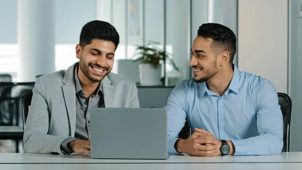 Muito feliz sorrindo funcionários do sexo masculino olhando para a tela do laptop, animado por inacreditáveis boas notícias. Colegas felizes celebrando recebimento atraiu notificação de investimento. Alegres cooperações no cargo — Fotografia de Stock