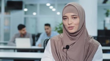 Yakın plan güzel Hintli genç Arap iş kadını modern mikrofon kullanıyor, ses ekipmanları video görüşmesi görüşmelerine katılıyor ya da internetten iş görüşmesi yapıyor, uzaktan iletişim kuruyor.