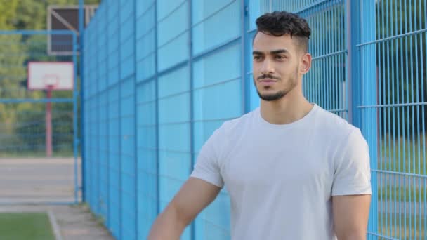Ικανοποιημένος ειλικρινής χαρούμενος Άραβας γενειοφόρος αθλητικός τύπος στα καλοκαιρινά αθλητικά, επιδεικνύοντας μυς, υπόσχεται καλά αποτελέσματα, σίγουρος για τη νίκη. Νεαρός ενεργητικός χαμογελαστός αθλητής εκφράζει υποστήριξη — Αρχείο Βίντεο