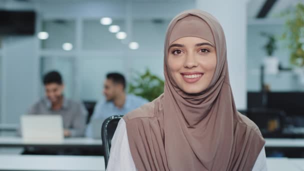 Ritratto di piacevole donna d'affari araba sorridente in hijab fiducioso broker assicurativo femminile direttore di banca hr assistente in open space donna ufficio guardando telecamera accogliente, pronto ad assistere il cliente — Video Stock