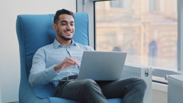 Relaxado feliz indiano empresário estudante trabalhador senta-se em poltrona confortável meditando, homem árabe calmo positivo relaxar quebrar segurar a mão atrás cabeça sonho descanso de computador esticar sentir paz de espírito — Vídeo de Stock