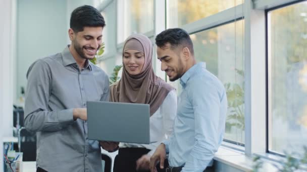 Πολυεθνικοί συνάδελφοι ακούνε Άραβες επικεφαλής της ομάδας εξηγήσει εταιρική εφαρμογή εργασίας σε διάφορους εργαζόμενους ινδούς επιχειρηματίες που αναζητούν σε οθόνη laptop που εργάζονται μαζί, την έννοια της ομαδικής εργασίας brainstorm — Αρχείο Βίντεο