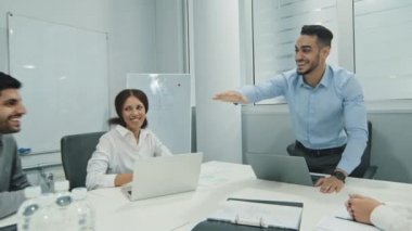 Heyecanlı, çok kültürlü, neşeli iş adamları toplanıp beşer jest yapıyorlar. Çok ırklı meslektaşları mutlu oluyor, takım ruhu gösteriyorlar. Zafer hedefini kutluyorlar.