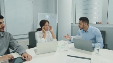 Hoşnutsuz genç Arap erkek patron çeşitli grupların toplanmasında çalışanları azarlıyor, kızgın takım lideri ofis brifinginde kötü sonuçlanan mali sonuçlardan dolayı astlarını azarlıyor.