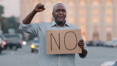 Konsepti bırak. Siyahi Afrikalı Amerikalı grevde protesto işareti gösteren ayrımcılığı protesto ediyor. Protestocu göçmen elinde karton pankart olan 