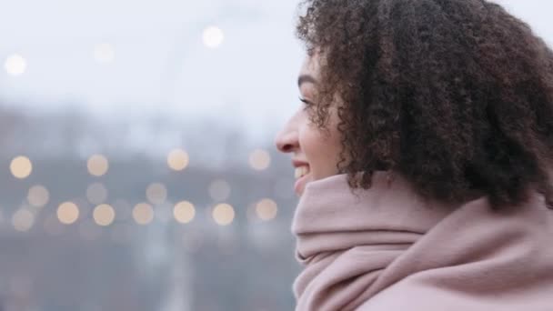 Detailní záběr krásná šťastná žena mladá africká americká dívka s kudrnaté vlasy nosí růžovou šálu stojí ve městě v zimě otáčí při pohledu na kameru ukazující palce nahoru jako gesto schválení podpory — Stock video