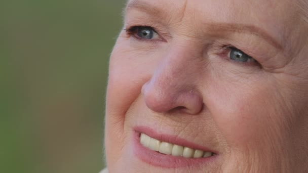 Zdjęcie głowy zbliżenie portret miłej uśmiechniętej dojrzałej kobiety. Szczęśliwy zdrowy w średnim wieku pani relaks samotnie, patrząc na bok, o szeroki uśmiech białe proste zęby. Pozytywna koncepcja przejścia na emeryturę — Wideo stockowe