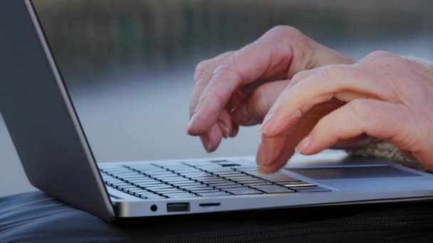 Senhora velha ou de meia idade usando o conceito de computador. Maduro mãos femininas digitando texto no teclado, idosa empresária trabalhando no laptop, escrevendo e-mails, se comunicando on-line, close-up view — Vídeo de Stock