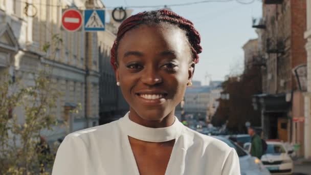 Retrato de bela mulher de negócios afro-americana feliz saiu menina estudante posando na rua da cidade. Fechar o dente feminino sorrindo com branco sorriso senhora olhando para câmera dental cliente ao ar livre — Vídeo de Stock