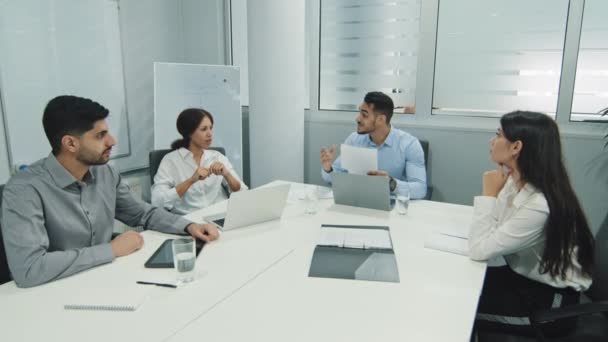 Diverse workers businesspeople working in modern office, sitting together at meeting multiethnic colleagues feels happy, showing team spirit gesture, celebrating news victory goal teamwork achievement — Stock Video