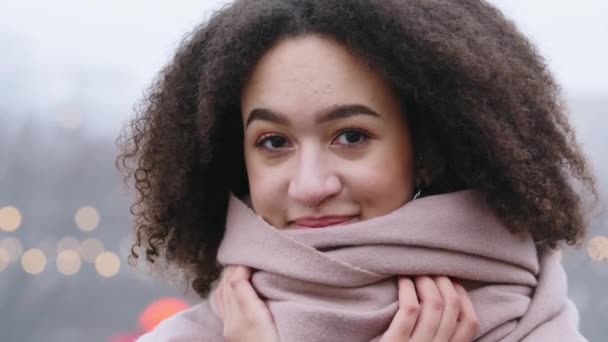 Vrouwelijk portret buiten mooi gemengd ras millennial gelukkig meisje vrouw dame toeristisch student vriendin met afro krullen stijlvolle kapsel staat in de stad met roze sjaal glimlachende tandheelkundige — Stockvideo