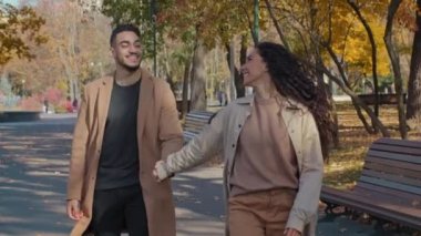 Genç ve aktif İspanyol çift, güz parkında el ele tutuşarak yürüyor. Güzel kız, mutlu, sakallı adam, kız arkadaşının etrafında dönüyor. Erkek ve kadın kucaklaşmaktan hoşlanıyor.