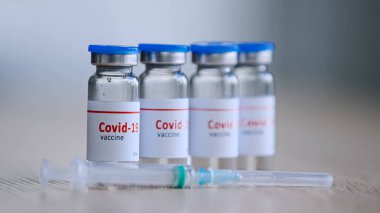 Hastalık için covid-19 aşısı olan dört şişe, salgın ilacı tedavisi ilacı şırınganın yanındaki hastane kliniği eczanesinde duruyor, aşı aşılama konsepti detayları...