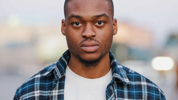 Portrait outdoors serious angry male face african american man looking at camera standing in urban city handsome confident guy looks street lifestyle. Real people close up facial confidence human gaze — Stock Photo, Image