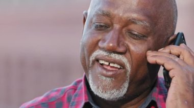Gülümseyen yaşlı siyahi adam cep telefonuyla konuşuyor, mutlu büyükbaba akrabalarıyla ya da torunlarıyla sohbet ediyor, olgun Afro-Amerikan erkeklerinin telefon görüşmelerini yapıyor, keyifli sohbetler ediyor.