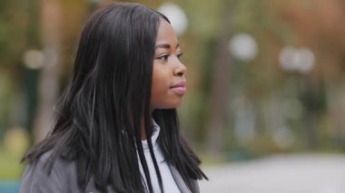 Genç pozitif kız beyaz dişleriyle gülümseyen kameraman iş kadınına bakıyor mutlu Afro-Amerikan kadını açık havada parktaki kadın portresindeki yetişkin, dalgın kadını kapatıyor.