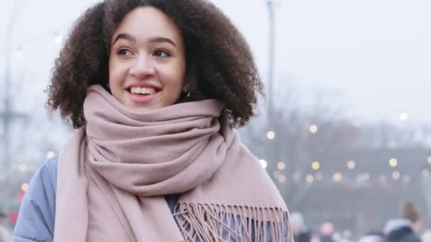 Ritratto di giovane studentessa afro-americana donna dai capelli ricci e in sciarpa rosa si erge in inverno in città sorridente ridente gode di bassa temperatura dell'aria camminare guardando nella macchina fotografica sognando — Video Stock