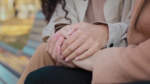 Cita romántica en el parque de otoño joven pareja sentada en el banco tocando los dedos de cerca amantes toman de la mano disfrutando de fin de semana al aire libre feliz chica desconocida y chico disfrutar del tiempo juntos concepto de relación — Vídeo de stock