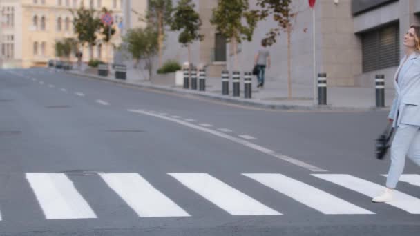 Jong mooi meisje model zakenvrouw student in stijlvolle blauw pak met zwarte handtas lopen springen cirkelen rotatie op crosswalk in de stad op de weg voetgangers kruising geluk leuk lopen dansen — Stockvideo
