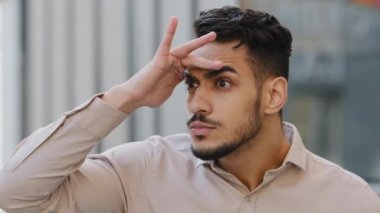 Yakın plan erkek şüpheli yüz portresi. Şehir dışında. Casus sakallı komik adam. Uzağa bakıyor.