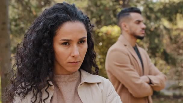 Close up offended upset curly girl in background angry guy family quarrel woman turns away from man hispanic couple stand ignoring each other outdoors conflict misunderstanding unhappy female feel sad — Stock Video