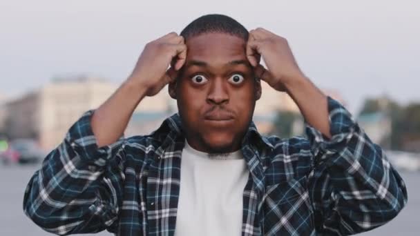 Afroamerikaner glücklich junger Kerl in lässigem T-Shirt isoliert in der Stadt Straße im Freien Blick auf Kamera schockiert überrascht Emotionen wow zeigt Hände Gehirn Explosion Kopf Geste Idee Problemkonzept — Stockvideo