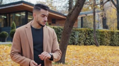 Bekleyen Arap bir adam, sonbahar parkında nöbet tutuyor. Mutlu bir şekilde eski arkadaşlarla tanışıyor. Yakın ilişkiler, güzel, İspanyol, kıvırcık kız sıkı sarılıyor.