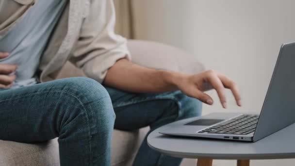 Nierozpoznawalny biznesmen facet freelancer student użytkownik męskie ręce wpisując na laptopie siedzi w domu kanapa czuje ból brzucha kontuzji trzymając ręce problemy z wątrobą trawienie potrzebują pomocy medycznej — Wideo stockowe