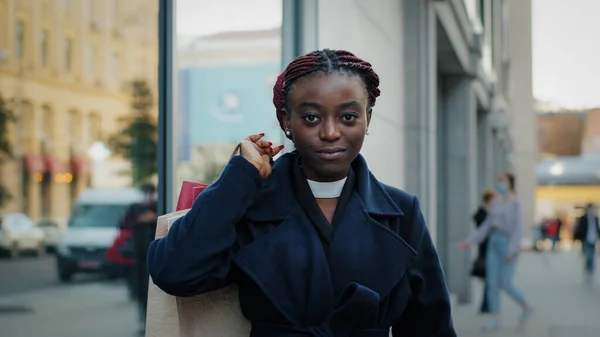 Portret buiten in de buurt van het bouwen van Afrikaanse Amerikaanse meisje serieus vertrouwen zakelijke vrouw kijken naar camera poseren holding shopping tassen met luxe korting goederen, vrouwelijke shopaholic met aankopen — Stockfoto