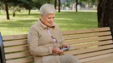 Gülümseyen, gri saçlı, başarılı, Kafkasyalı, elinde avroyla dışarıda gezen olgun bir bayan. Kadın emekli, nakit para miktarını kontrol ediyor, kağıt banknotları sayıyor. Mali işler, tasarruf kavramı