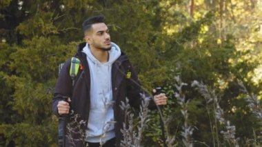 Yorgun erkek öğrenci gezgin, bin yıllık sakallı Arap adam dinlenmek için durdu. Sırt çantası ve tahta sırıklarla seyahat eden çekici aktif atletik genç adam. Yolda dur konsepti