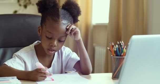 Vážná zaměřená holčička africký americký dítě sledování video kreslení lekce na online učitel lektor opakuje čerpá na papíře s marker, vzdálený domácí učení koncept během pandemické karantény — Stock video