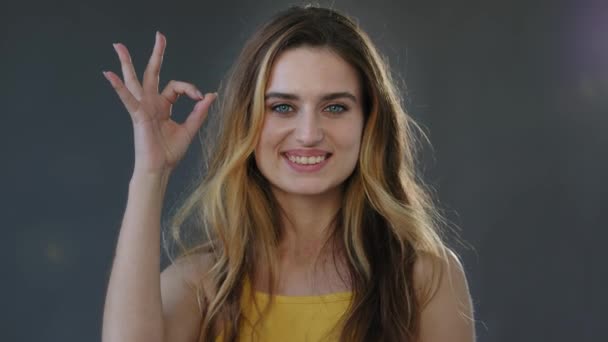 Female portrait successful feminist woman millennial girl lady blonde model shows ok sign symbol everything okay well good perfect gesture smiling looking at camera standing on gray studio background — Stock Video