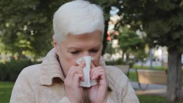 Allergica signora di mezza età si sente male avendo sintomo influenzale, malato vecchia donna matura tenere starnuti tessuto ottenuto febbre beccato freddo soffiando naso che cola nel fazzoletto, malato. Concetto di allergia, vista da vicino — Video Stock