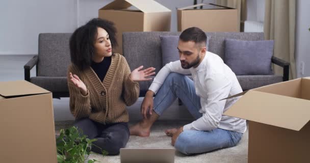 Mixed race young angry upset people family interracial couple with bad relationship sitting surrounded by boxes quarreling screaming negative mood arguing looking into laptop, divorce and move concept — Video Stock