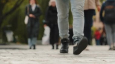 İnsan ayaklarının yakın görüntüsü, kalabalık caddelerde yürüyen insanlar, sonbahar günü şehir merkezinde şehir sakinlerinin hareketli kalabalığı, yoğun saatlerde tanınmayan yayalar. Çizmeli bir sürü yolcu.