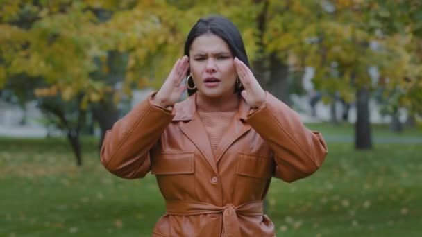 Close-up boos Spaanse meisje buiten staan lijden aan het gevoel onwel hoofdpijn malaise pijn wrijft tempel opgewonden jonge vrouw bezorgd over slecht nieuws moe pijnlijke gevoelens chronische migraine koorts — Stockvideo